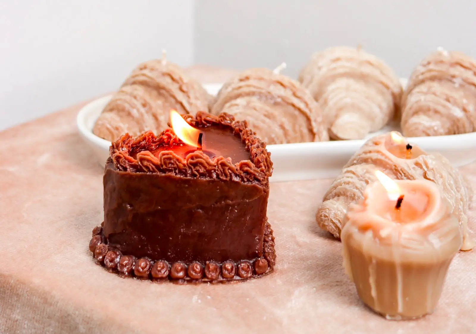 Burning brown cake candle with other nude candles around it