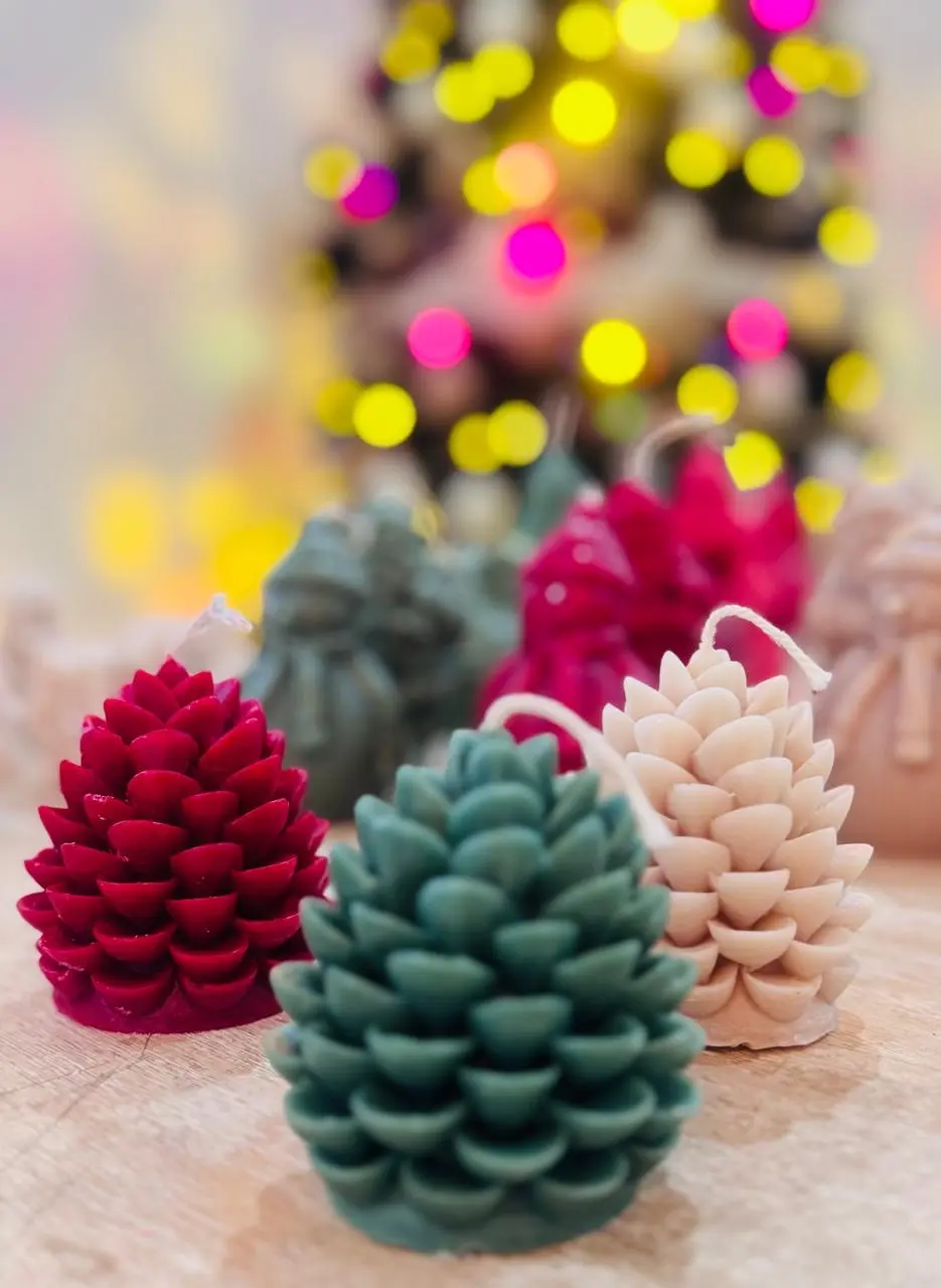 Red, green and nude candles of pinecones.