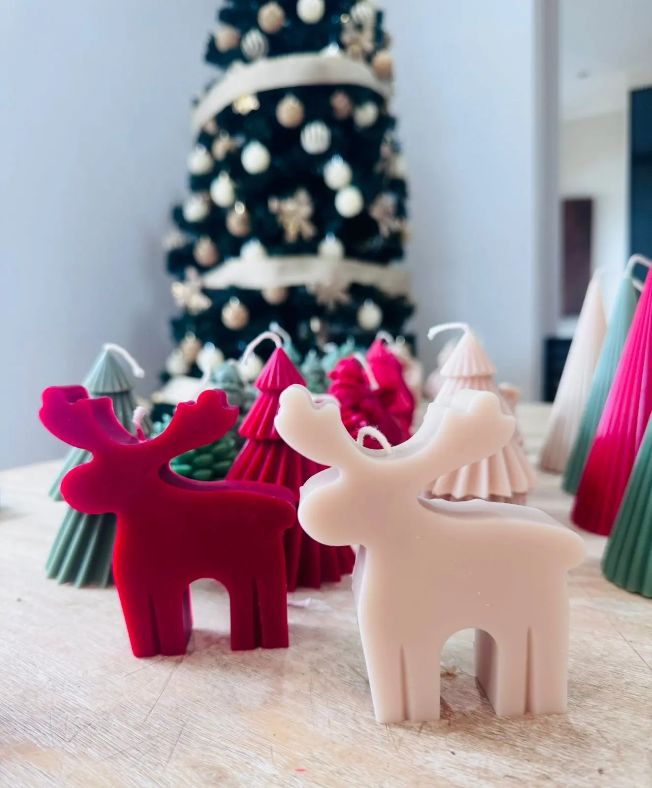 Red, green and nude candles of reindeers.