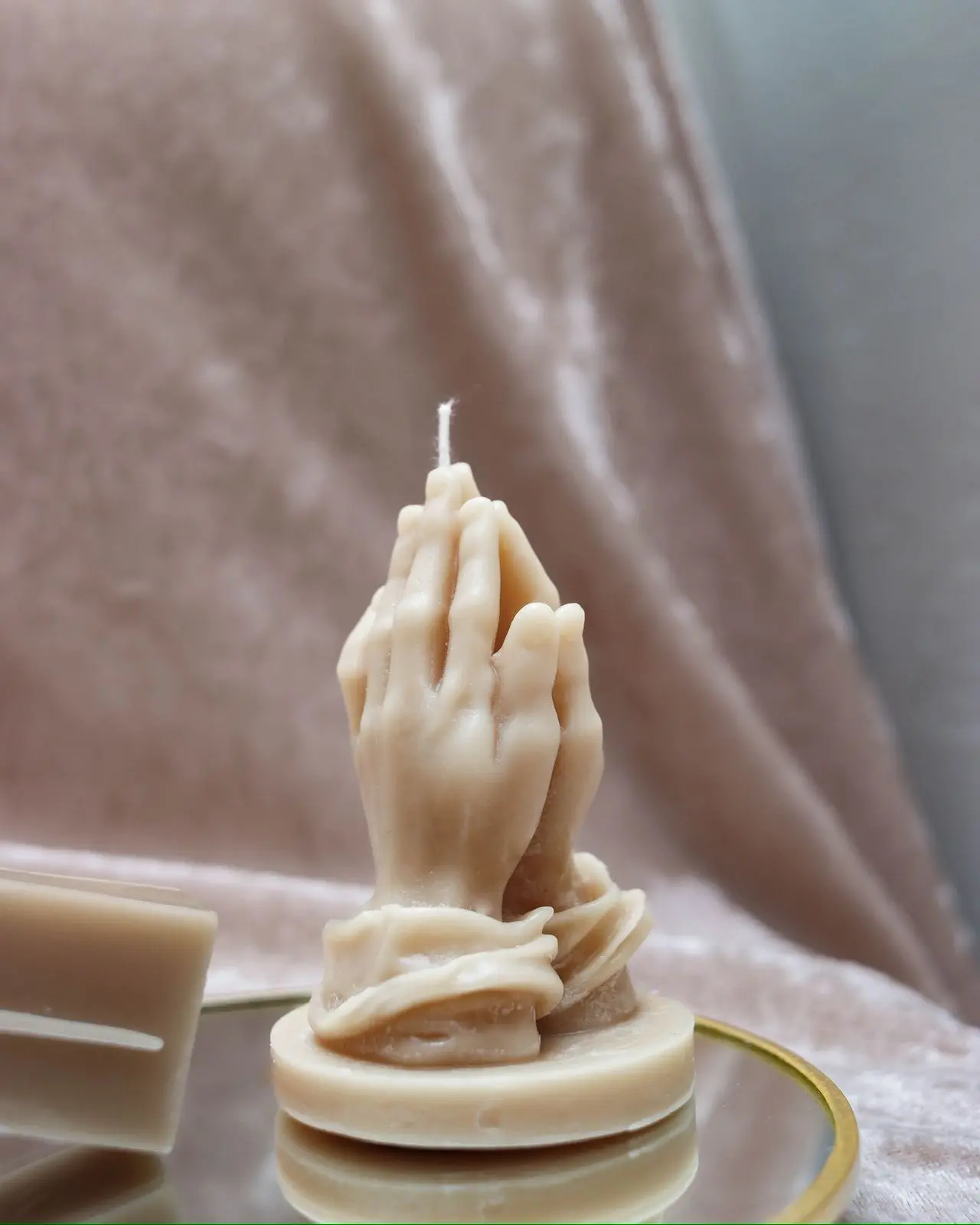 Nude candle of praying hands.