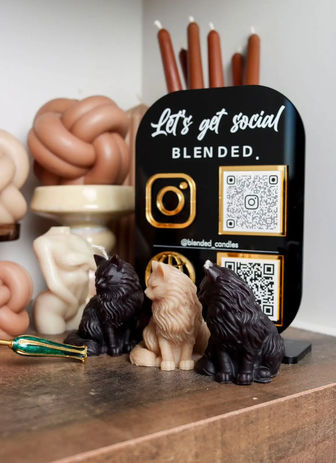 Black acrylic social media sign for Blended Candles along with nude candles.